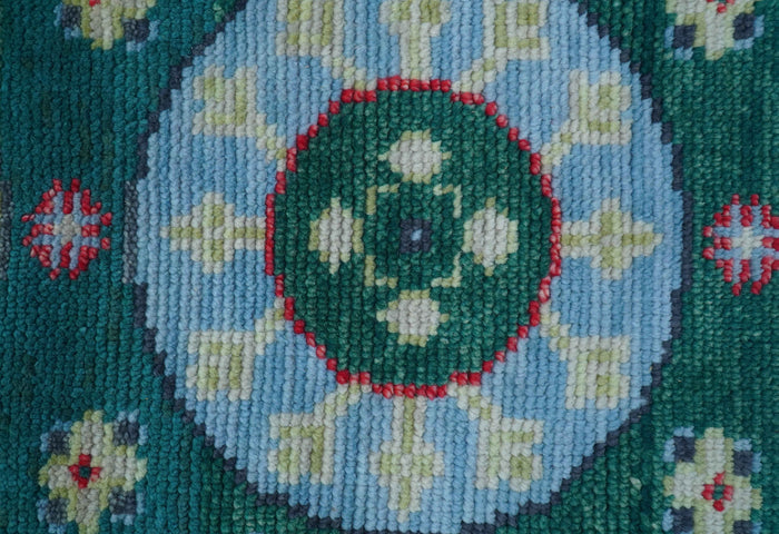 Hand-knotted Khotan teal wool area rug with central circular medallion and floral motifs
