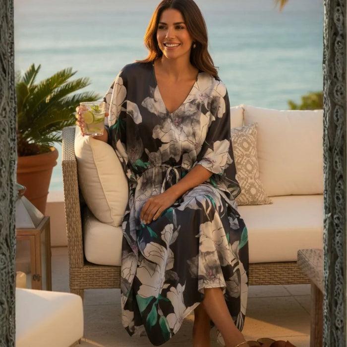 Woman in a floral dress sitting on a patio with a scenic background