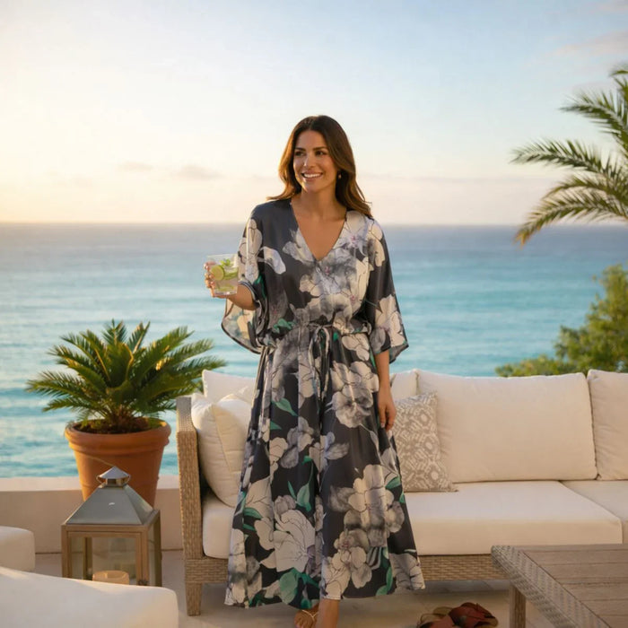 Woman in a floral dress standing on a patio with ocean view