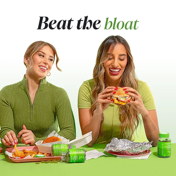 Two smiling women at a table with burgers and fries, a bottle of Novomins Apple Cider Vinegar Gummies beside them, under the heading 'Beat the bloat'.