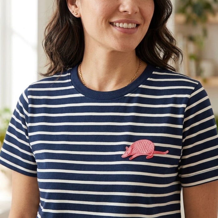 Woman wearing a navy and white striped shirt with an embroidered armadillo design.