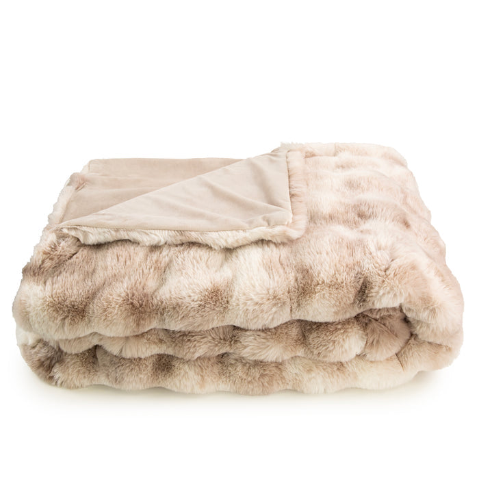 Folded beige and brown faux fur throw blanket on a white background
