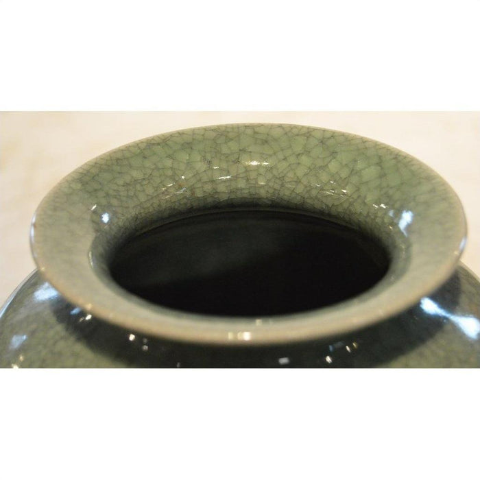 Close-up of green celadon porcelain altar vase with crackled glaze texture.