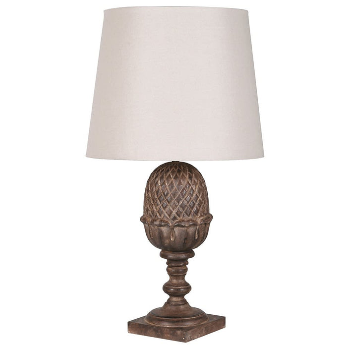 A table lamp with a textured, dark brown pinecone-shaped metal base and a tapered off-white fabric drum shade, shown against a plain white background.