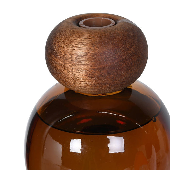 Brown glass bottle with wooden cap on a white background