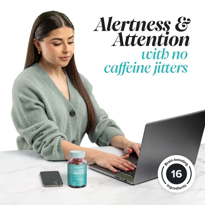 A woman in a sage green cardigan works at a laptop with a bottle of Novomins Focus Gummies on the desk, headed 'Alertness & Attention with no caffeine jitters', with a brain-boosting 16 ingredients badge.