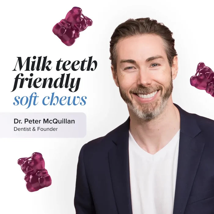 Dr Peter McQuillan, dentist and founder, smiling in a navy blazer on a white background with floating magenta gummy bears, beside the text 'Milk teeth friendly soft chews'.