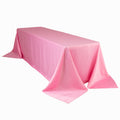 Pink tablecloth draped over a table, showcasing smooth, shiny fabric.