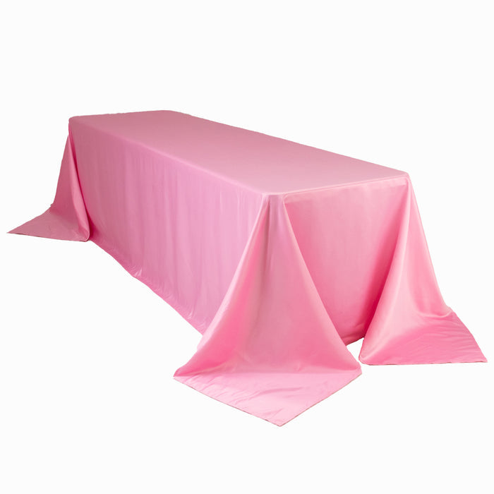 Pink tablecloth draped over a table, showcasing smooth, shiny fabric.