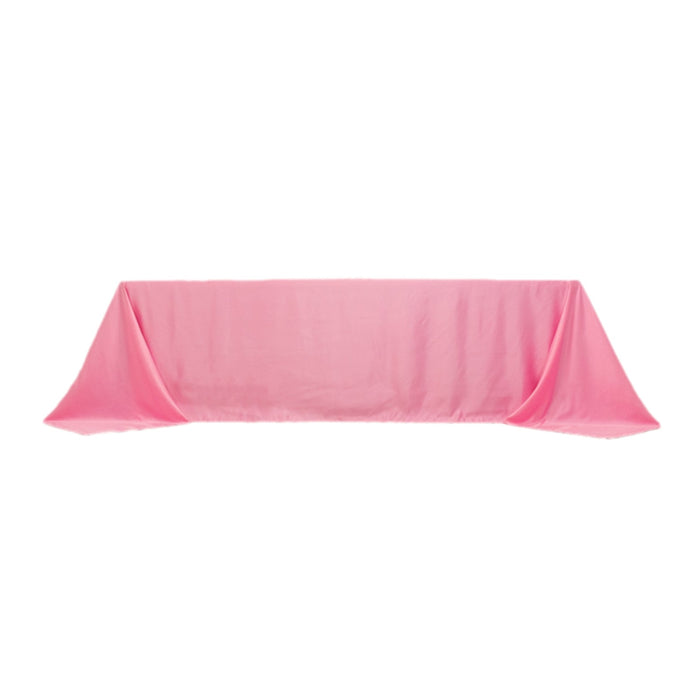Pink tablecloth with elegant draping on a plain backdrop