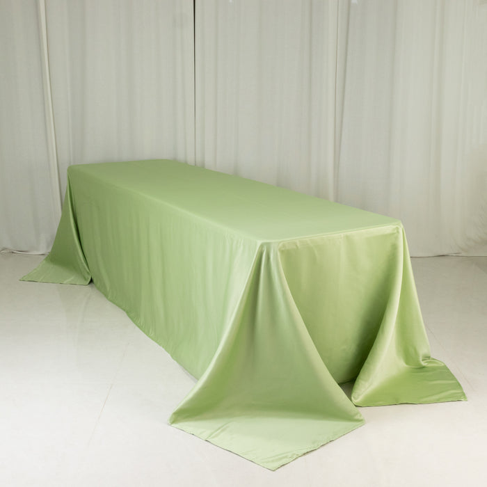 Green tablecloth draping a long table in a studio setting.