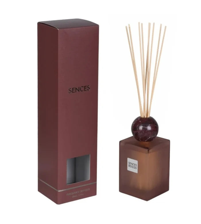 Sences reed diffuser set with a dark brown rectangular glass bottle, natural reed sticks, and its matching dark brown cardboard packaging box on a white background.