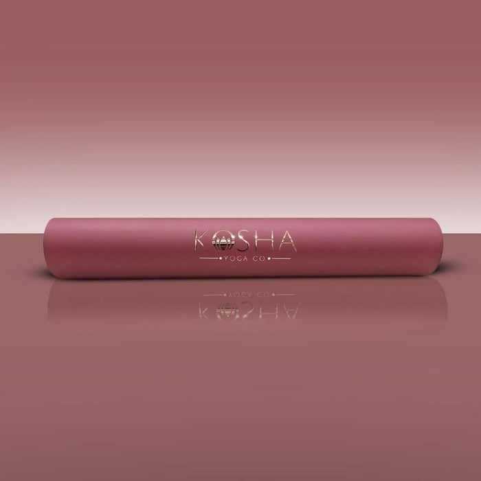Pink yoga mat with 'KOSHA YOGA CO' branding on a matching pink background