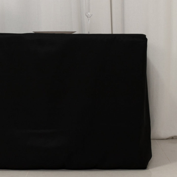 Black table cover draped over a table in a minimalist setting.