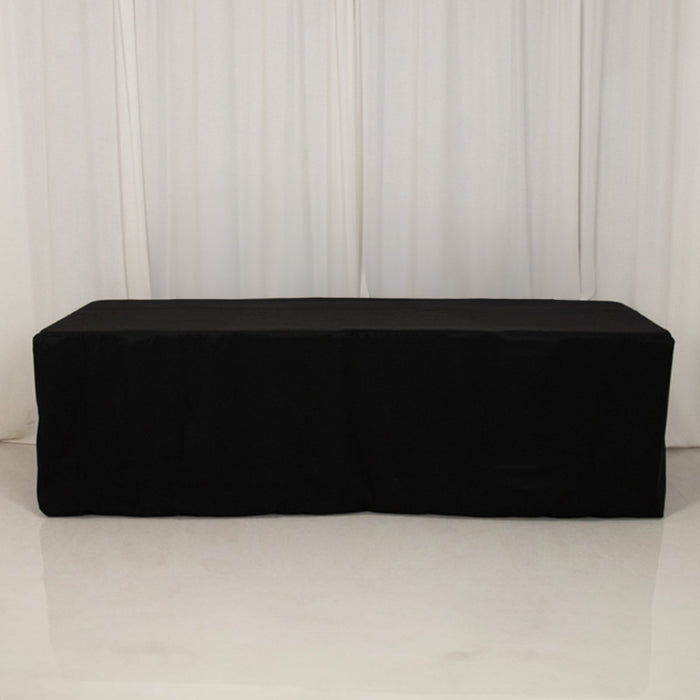 Black table cover draped over a rectangular table in a studio setting