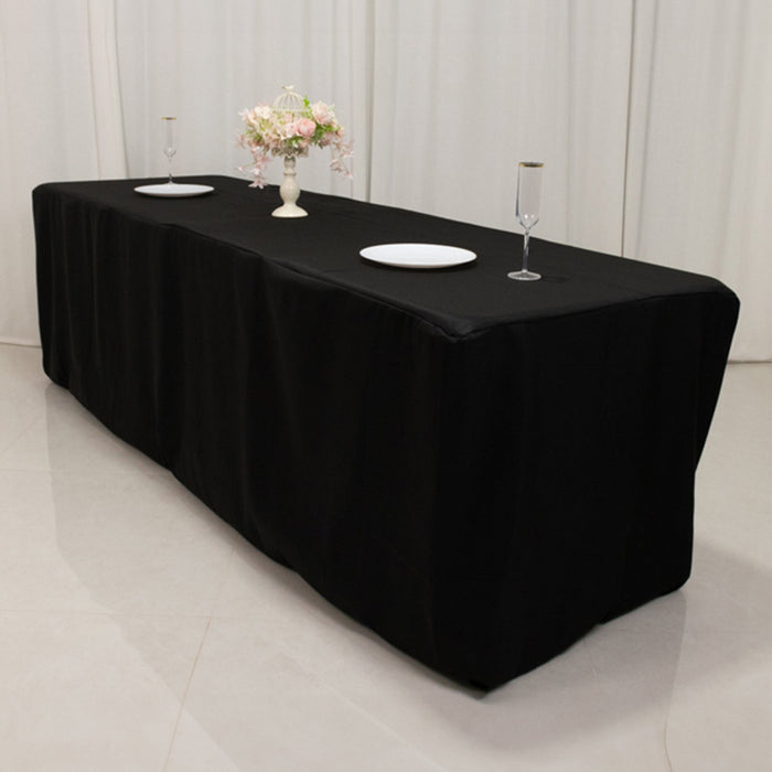 Black tablecloth draped over a long table with decorative items on top.