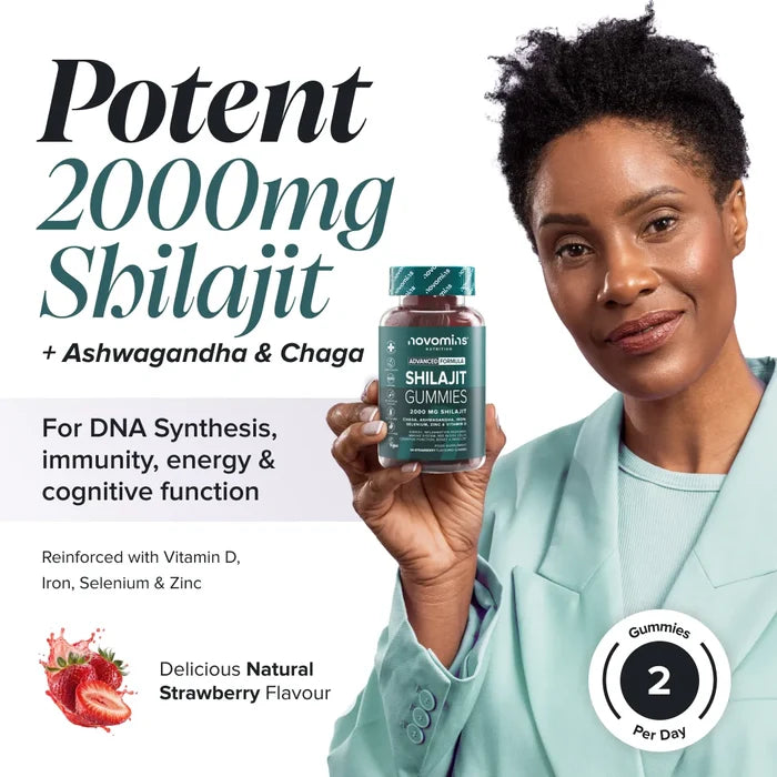 A smiling woman in a mint green blazer holds a bottle of Novomins Shilajit Gummies, headed 'Potent 2000mg Shilajit plus Ashwagandha and Chaga for DNA synthesis, immunity, energy and cognitive function', reinforced with vitamin D, iron, selenium and zinc, in a natural strawberry flavour with two gummies per day.
