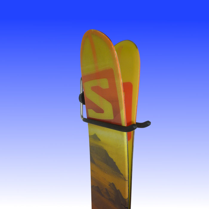 Wall-mounted hook holding a pair of skis