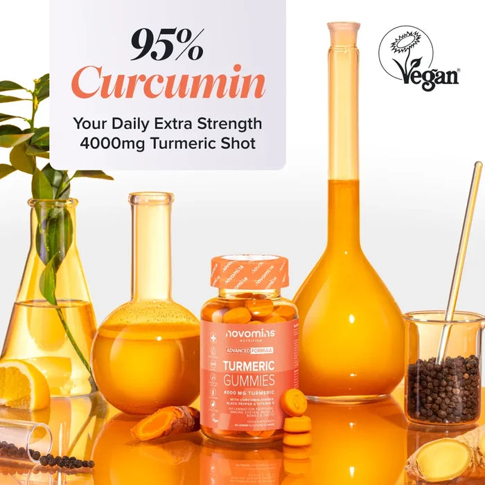 A bottle of Novomins Turmeric Gummies among laboratory glassware filled with orange liquid, fresh turmeric root, lemon and black peppercorns, headed '95% Curcumin, your daily extra strength 4000mg turmeric shot', with a Vegan Society logo.