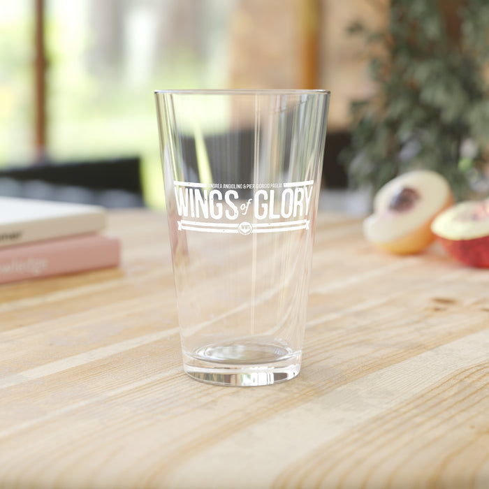 Wings Of Glory: WW1 Pint Glass 16oz with a clear design on a wooden table