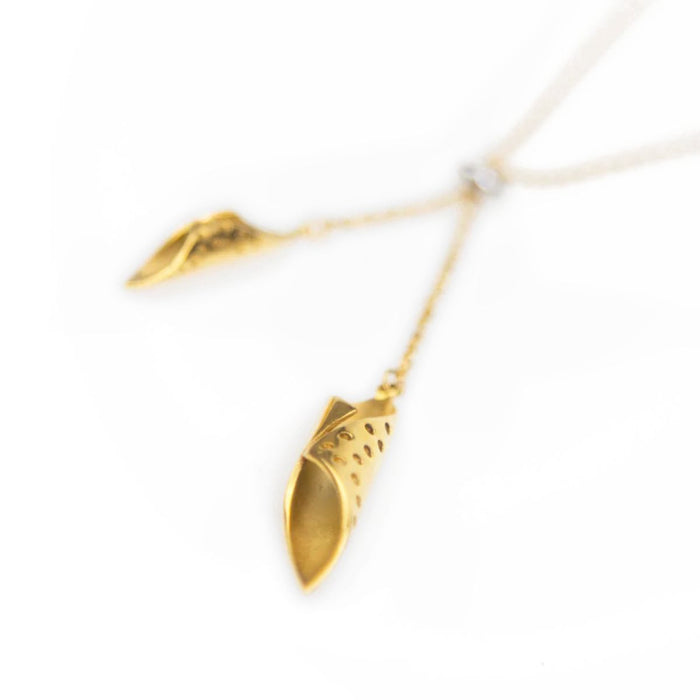 Gold leaf-shaped pendant necklace on a white background
