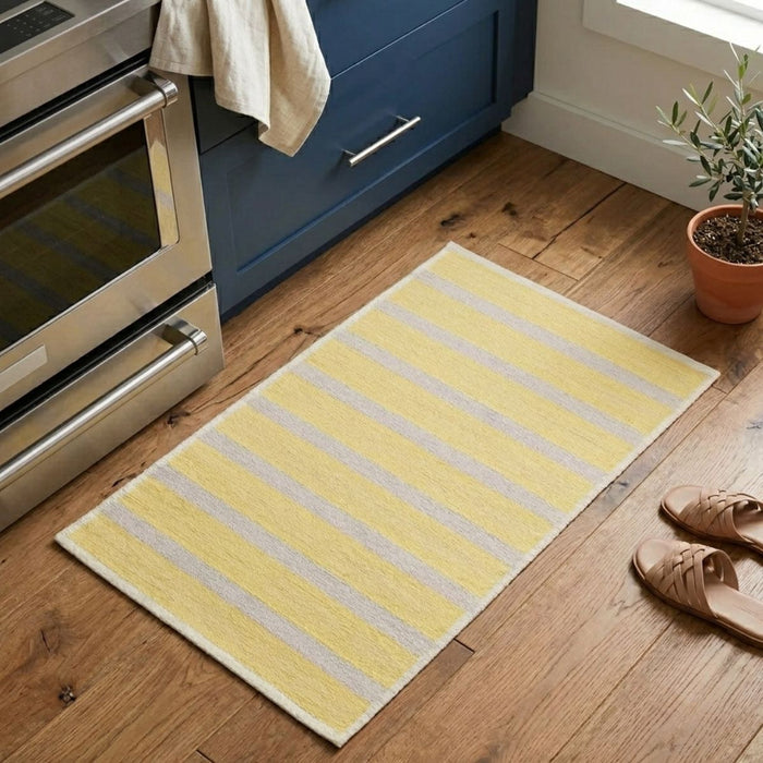 Yellow striped rug on a wooden floor in a kitchen setting